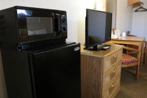 a black refrigerator with a tv on top of it at Highland Country Inn Flagstaff in Flagstaff