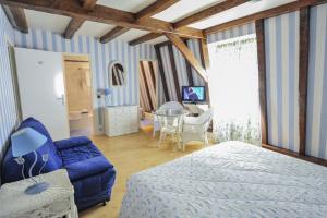 a bedroom with a blue bed and a table at Villa Ric in Saint-Céré