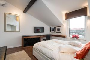 1 dormitorio con cama blanca y ventana en Apartament nad dachami Krakowa en Cracovia