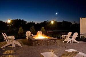 a fire pit with white chairs around it at night at Saratoga Casino Hotel in Saratoga Springs