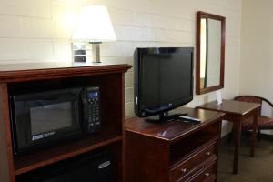 a hotel room with a microwave and a television at Budget Inn Flagstaff in Flagstaff