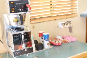 a kitchen counter with a coffee maker on a stand at Budget Inn Flagstaff in Flagstaff