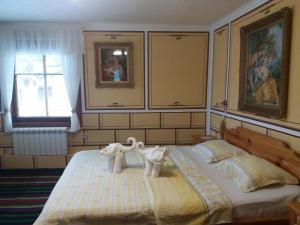 Un dormitorio con dos animales de toalla en una cama. en Guest Rooms Bashtina Striaha, en Koprivshtitsa