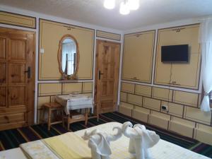 Habitación con cama y TV en la pared. en Guest House Bashtina Striaha, en Koprivshtitsa