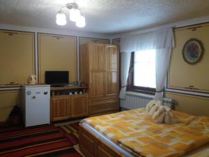 1 dormitorio con 1 cama, TV y ventana en Guest House Bashtina Striaha, en Koprivshtitsa
