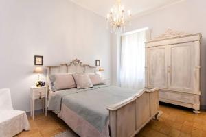 a bedroom with a large bed and a chandelier at Ca'Lavalle B&B in Urbino