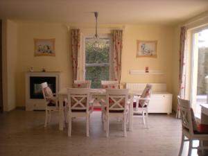 a dining room with a white table and chairs at Ferienhaus Arielle in Glowe