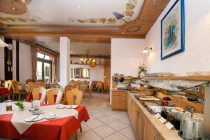 a restaurant with a table and chairs and a kitchen at Landhotel Hopp Garni in Heßheim