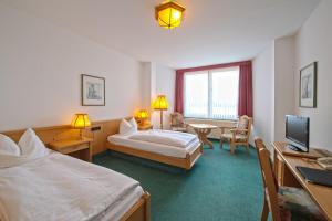 a hotel room with a bed and a desk at Landhotel Hopp Garni in Heßheim