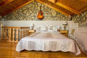 - une chambre avec un lit et un mur en pierre dans l'établissement Hara's view, à Lassi