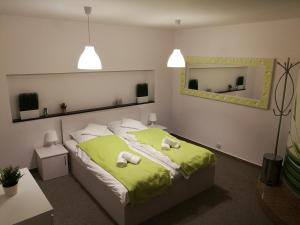 a bedroom with a green bed with two towels on it at Apartament na Różance in Wrocław