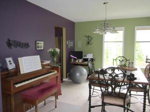 a living room with a piano and a table at Creekside B&B in Nelson