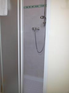 y baño con ducha y puerta de cristal. en B&B Villa Dora, en Capo dʼOrlando