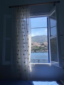 a bedroom window with a view of the water at Nikolitsi Studios in Symi