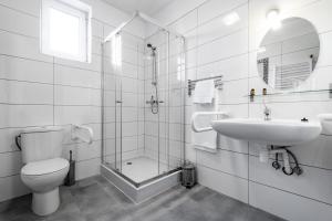 a bathroom with a toilet and a sink and a shower at L26 Łopuszańska in Warsaw