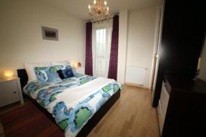 a bedroom with a bed with a colorful comforter at ASKI Powiśle Copernicus Apartment in Warsaw