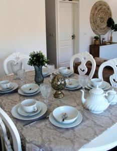 une table avec des plats blancs et de la vaisselle en porcelaine dans l'établissement Lisboa 1912 - Alojamento de Charme, à Lisbonne