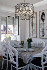 a dining room table with white chairs and a chandelier at Lisboa 1912 - Alojamento de Charme in Lisbon