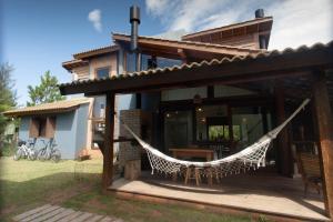 a house with a hammock outside of it at Casa da Ferrugem in Garopaba