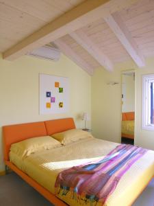 ein Schlafzimmer mit einem orangenen Bett in einem Zimmer in der Unterkunft Casa Nova in Burano
