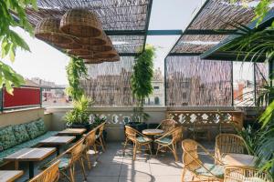 a patio with tables and chairs on a balcony at Hotel Casa Bonay & Spa in Barcelona