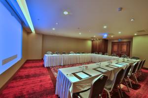 Una sala de conferencias con mesas y sillas y una gran ventana. en Adelmar Hotel Istanbul Sisli, en Estambul