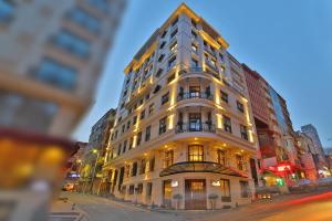 Un edificio alto y blanco en una calle de la ciudad. en Adelmar Hotel Istanbul Sisli, en Estambul