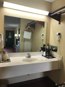 uma casa de banho com um lavatório e um espelho grande em Americas Best Value Inn & Suites - Little Rock - Maumelle em Maumelle