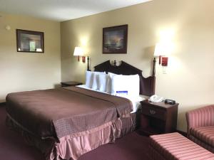 Habitación de hotel con cama y silla en Americas Best Value Inn & Suites - Little Rock - Maumelle, en Maumelle
