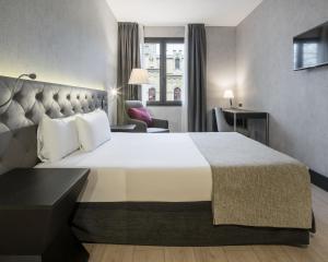a hotel room with a large bed and two lamps at Ilunion Bel-Art in Barcelona