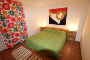 a bedroom with a green bed and a painting on the wall at Apartment Dusanka in Fažana