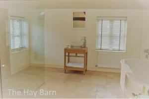 a bathroom with a tub and a sink and a bath tub at The Coach House Denton in Grantham