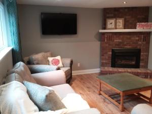 sala de estar con 2 sofás y chimenea en Westwood Cottage License #045-2020, en Niagara on the Lake