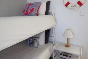 ein Schlafzimmer mit einem Etagenbett und einem Beistelltisch in der Unterkunft Chamomile Cottage 2 in Muizenberg