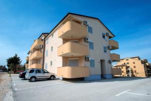 a building with a car parked in a parking lot at Apartment Frlan in Ližnjan