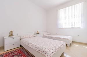 een slaapkamer met 2 bedden en een raam bij Apartments Marich in Medulin