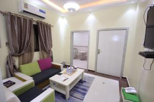 ein Wohnzimmer mit einem Sofa und einem Tisch in der Unterkunft Nakhil Moon Serviced Apartments in Wadi ad-Dawasir