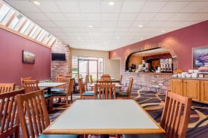 a dining room with tables and chairs in a restaurant at Super 8 by Wyndham State College in State College