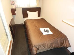 um pequeno quarto com uma cama num quarto em Hotel Suntargas Otsuka em Tóquio