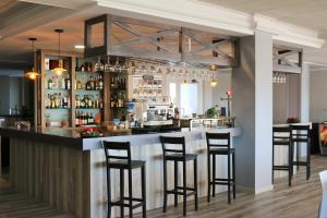 a bar in a restaurant with stools at Te Maná Hotel in Torreblanca