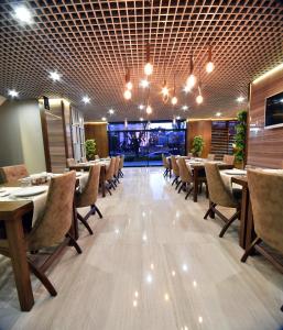 un ristorante con tavoli e sedie in legno e luci di The Elegant Hotel a Istanbul