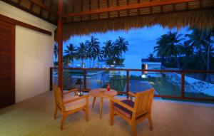 Anema Wellness & Resort Gili Lombok - Diving Center PADI في تانجونغ: غرفة طعام مع طاولة وكرسيين