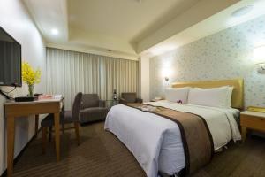 um quarto de hotel com uma cama grande e uma escrivaninha em Forward Suites Ⅰ em Taipei mais 39 fotografias