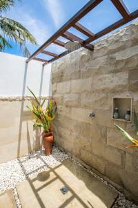 a stone wall with a window and a plant at Wilson's Retreat in Gili Trawangan