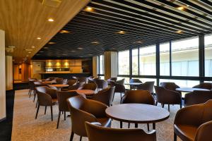 a restaurant with tables and chairs and windows at Grampus Sea in Shirahama