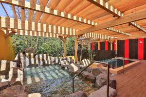 a hot tub in a house with a wooden ceiling at Grampus Sea in Shirahama