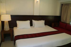 a hotel room with a bed and a red couch at Palita Lodge - SHA Plus in Haad Rin