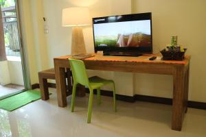 a desk with a television and a green chair at Palita Lodge - SHA Plus in Haad Rin