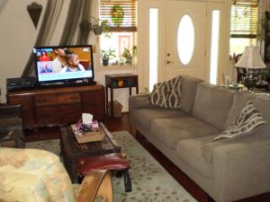 a living room with a couch and a flat screen tv at Grandeur Farm Retreat in Marshallville
