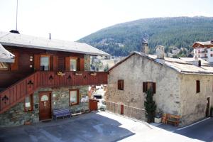 a large stone house with a wooden deck on it at Baita De Anna in Valdidentro